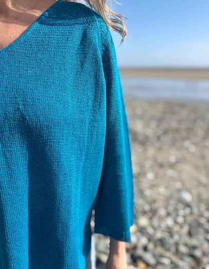 woman wearing turquoise linen knit sweater on the beach