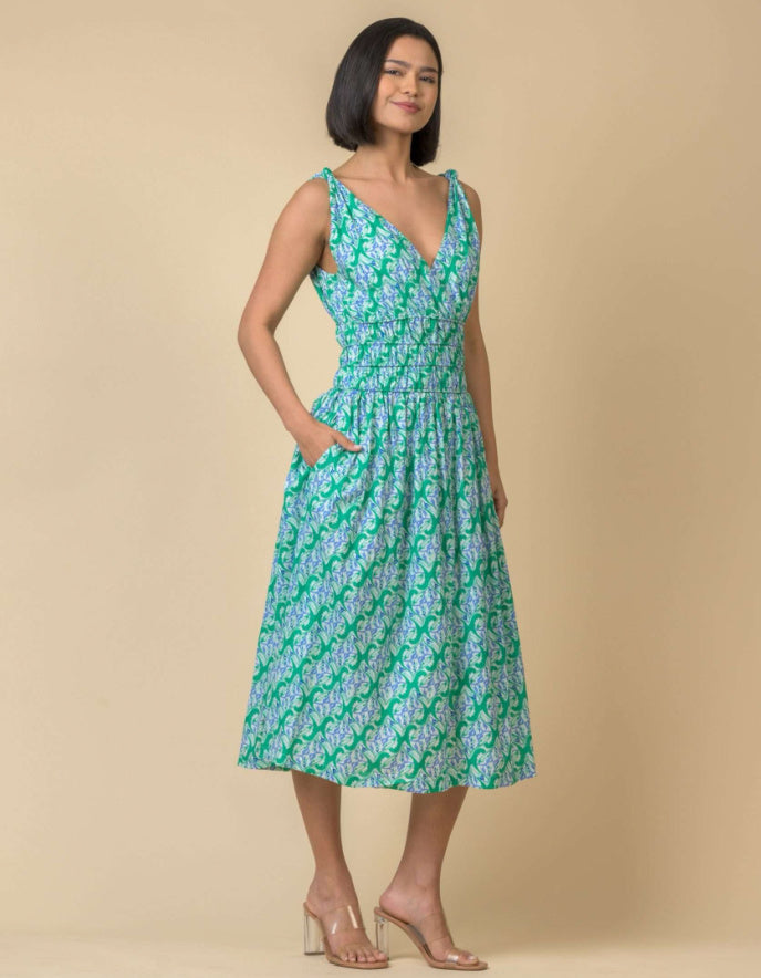 Woman wearing a green floral dress against a beige background