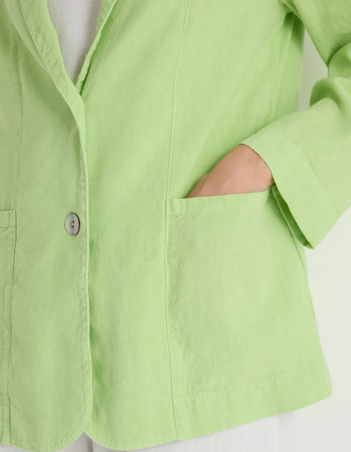 Close-up of a light green shirt with a button on a white background