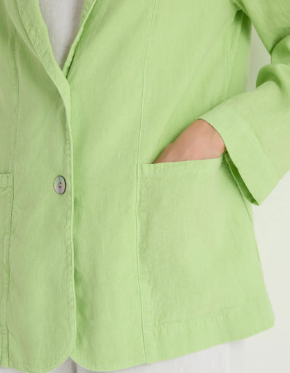 Close-up of a light green shirt with a button on a white background