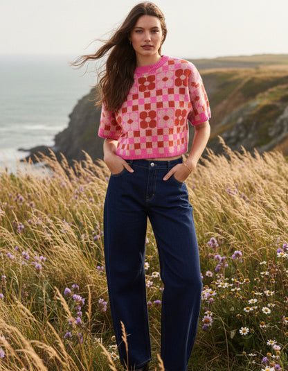 woman wearing a checkerboard and flower pink and red tank top sweater
