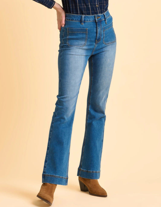 Person wearing blue jeans on a beige background