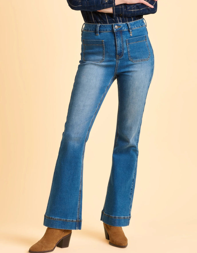 Blue jeans worn by a person on a beige background