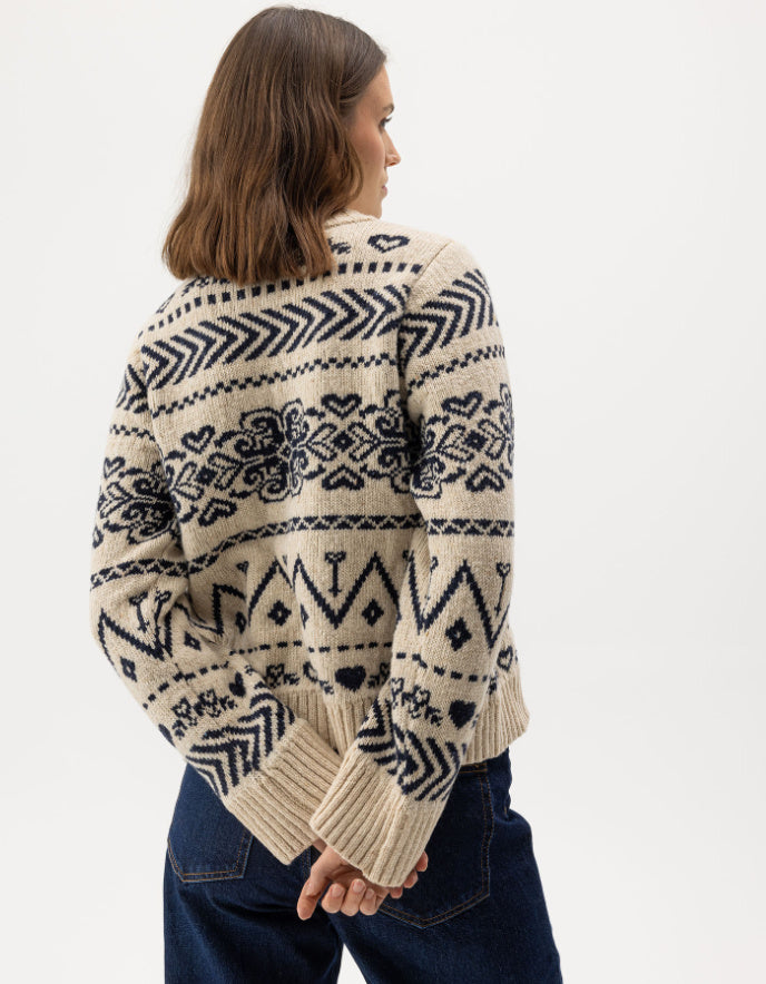 Woman wearing a cream Fairisle patterned scandi sweater on a white background