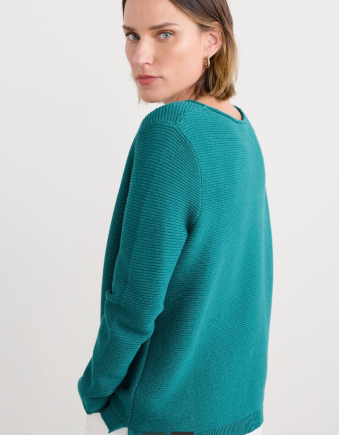 Woman wearing a teal cottonsweater on a white background