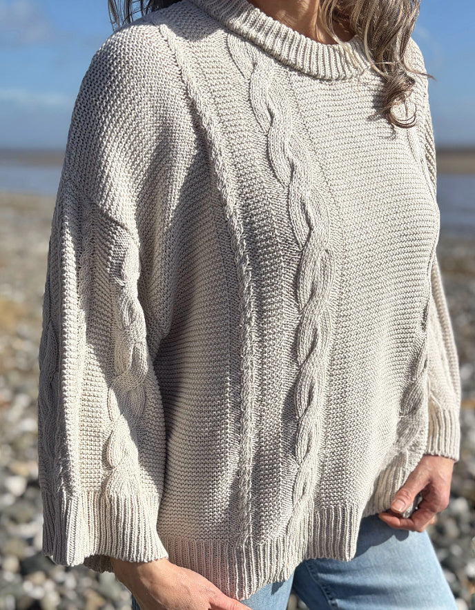 woman wearing cotton cable sweater on a beach