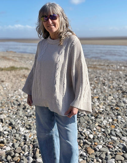 woman wearing cotton cable sweater on a beach