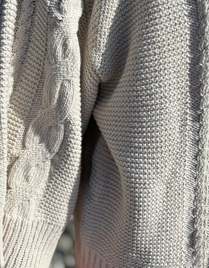 woman wearing cotton cable sweater on a beach