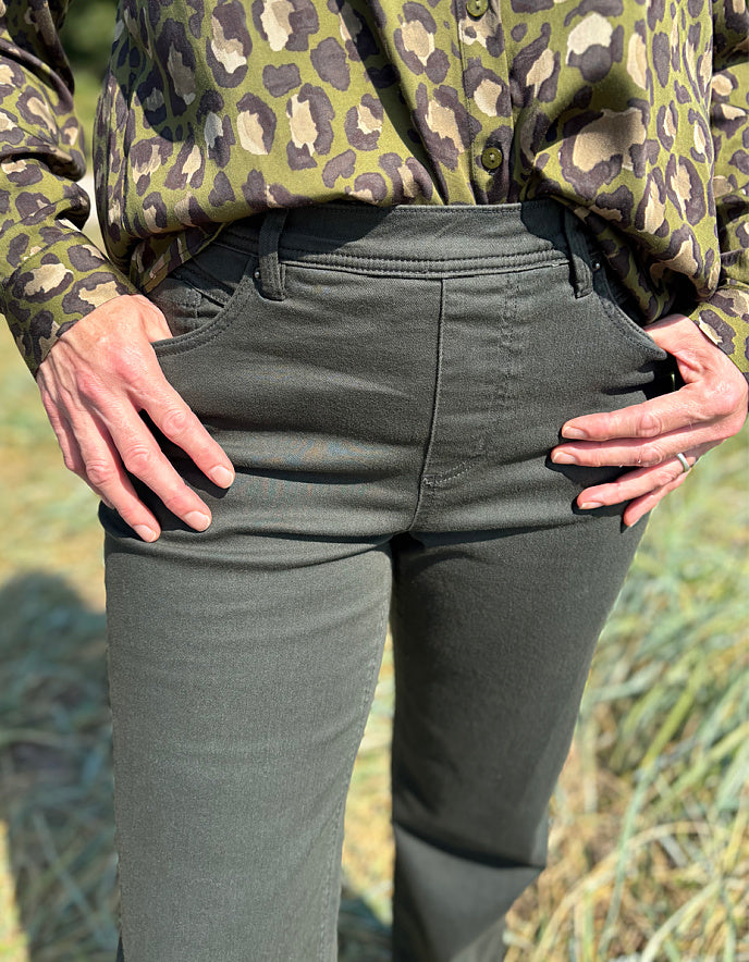 Person wearing camouflage shirt and green pants with a natural background