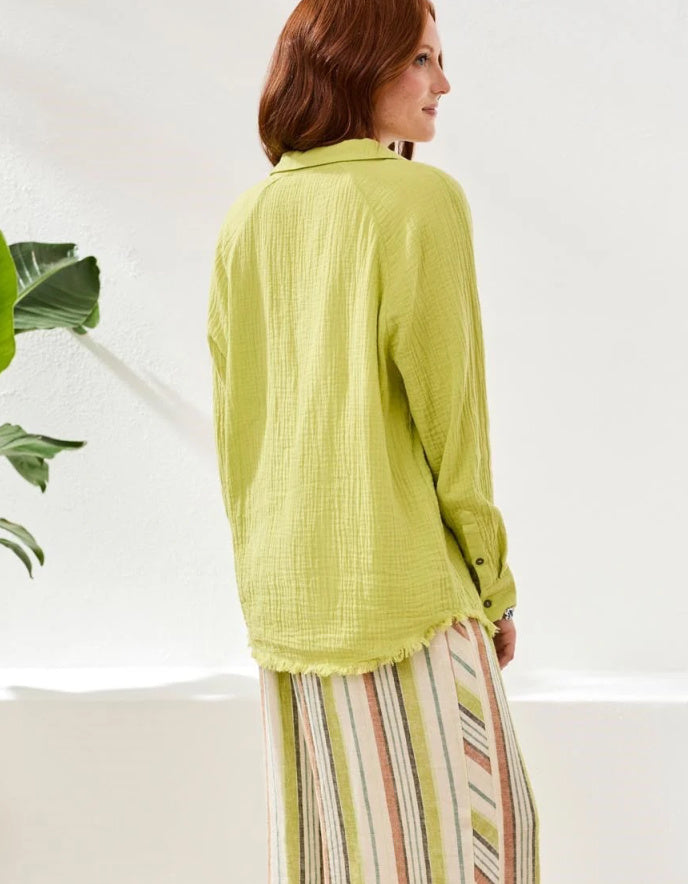 Woman wearing a light green textured shirt with a white background