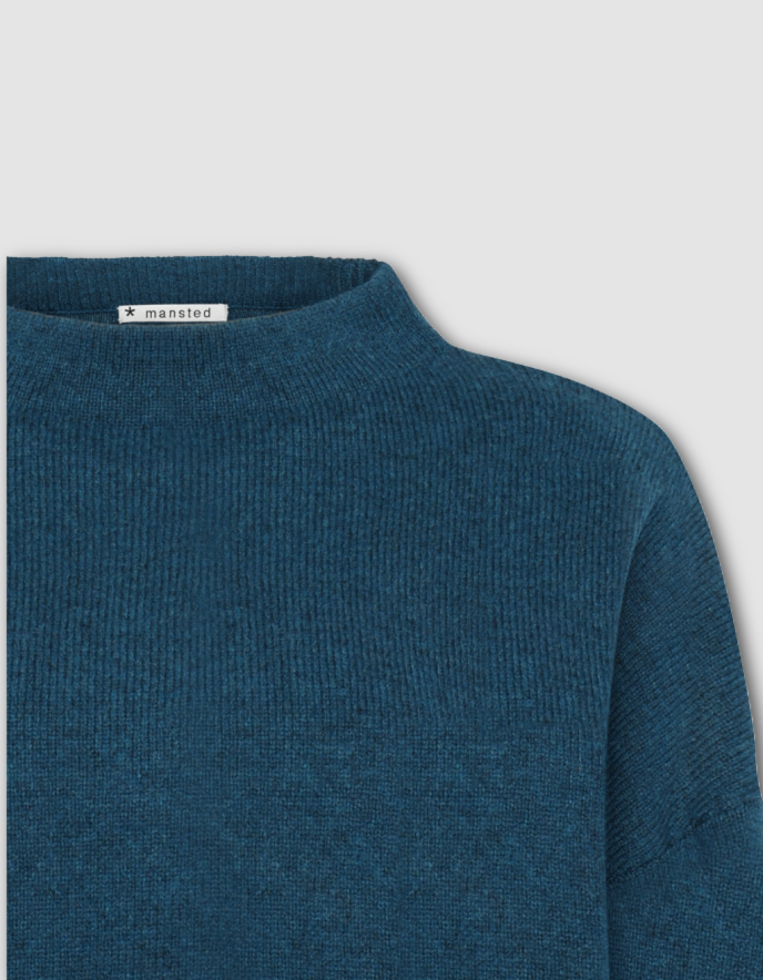 Blue sweater with a brand label on a light gray background