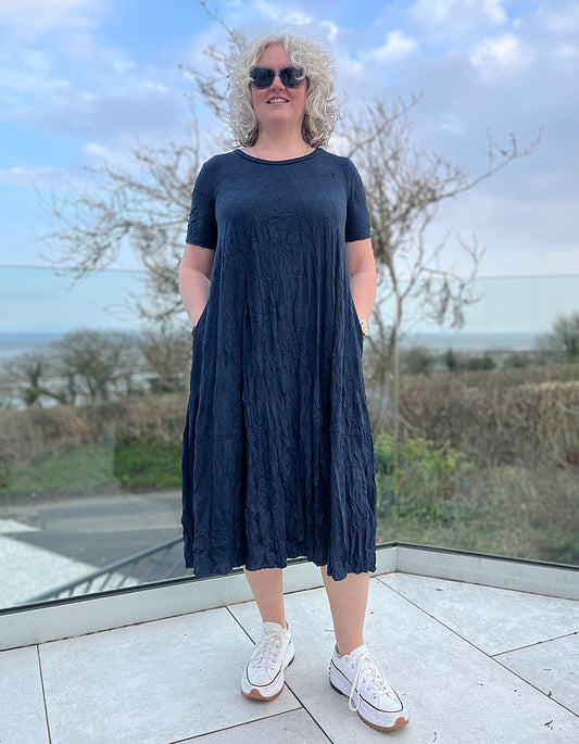 loose fit cotton jersey bubble dress with scoop neck, short sleeves and pockets, midi length in navy blue crinkle effect fabric