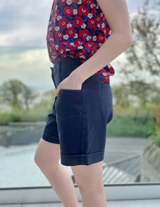 navy cotton shorts with mid thigh length front and back pockets and button and zip opening