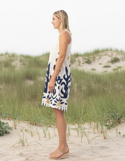 woman wearing white cotton shift dress with navy graphic print in the sand dunes