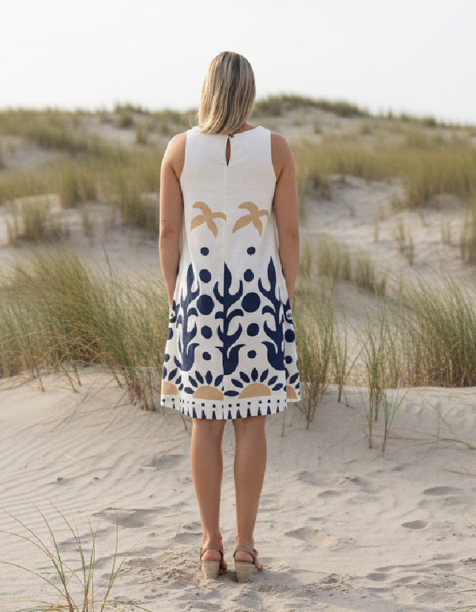 woman wearing white cotton shift dress with navy graphic print in the sand dunes