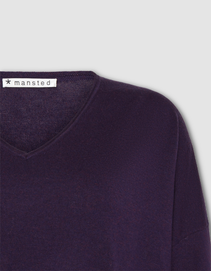 Purple sweater with 'mansted' label on a light gray background