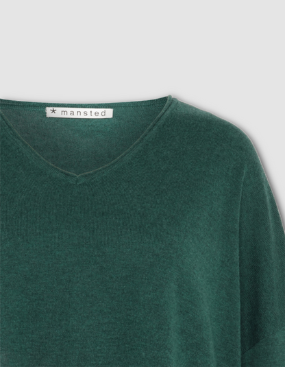Green sweater with 'mansfeld' label on a light gray background