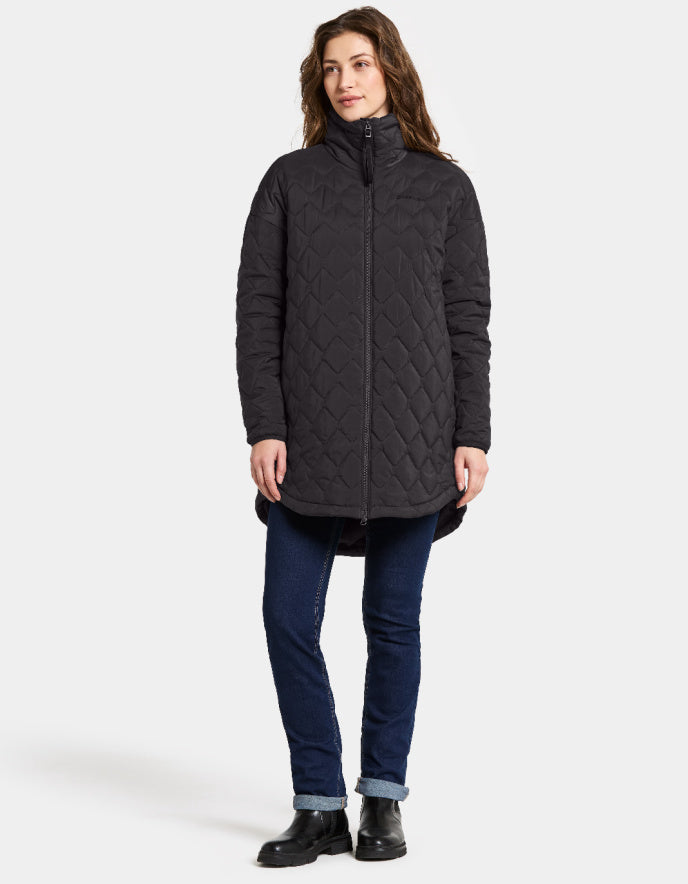 Woman wearing a dark quilted coat on a white background