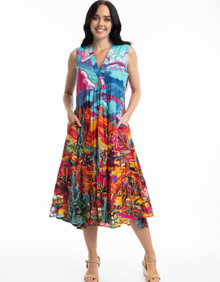 sleeveless sun dress made from crinkle cotton with v neckline and pockets and featuring a brightly coloured Mexican themed print