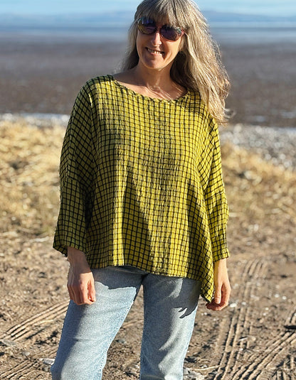 oversized one size top with drape. ochre shade of green with black check print, round neckline