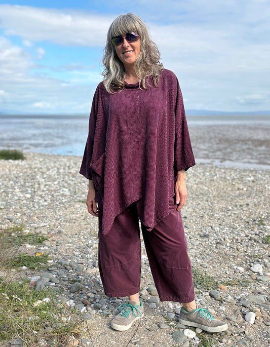 woman wearing oversized purple burgundy tunic and lantern shaped trousers