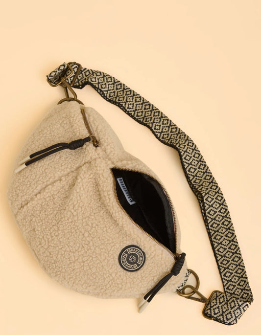 Beige fleece-lined bag with a patterned strap on a beige background