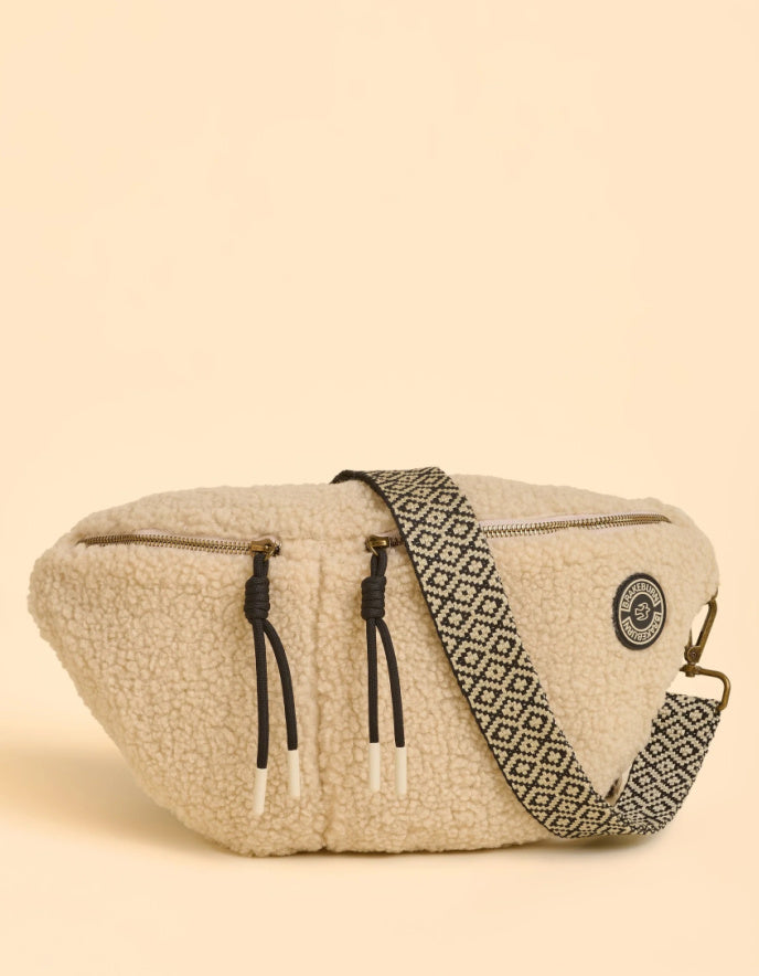 Beige woven bag with black geometric pattern on a beige background