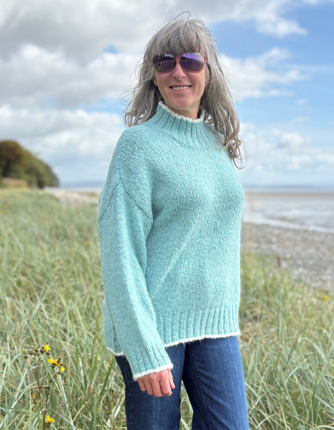 woman wearing a pale blue cosy turtle neck sweater with jeans