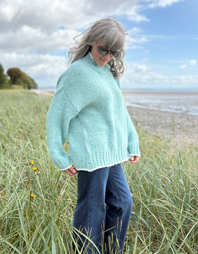 woman wearing a pale blue cosy turtle neck sweater with jeans