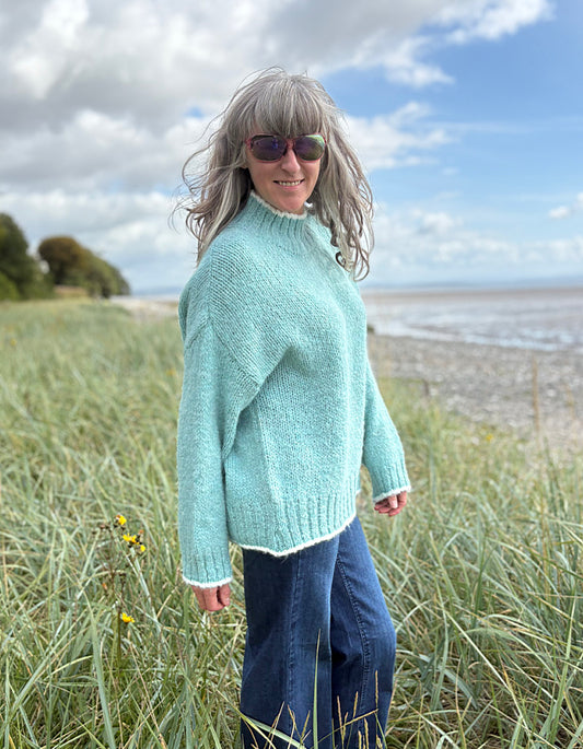 woman wearing a pale blue cosy turtle neck sweater with jeans