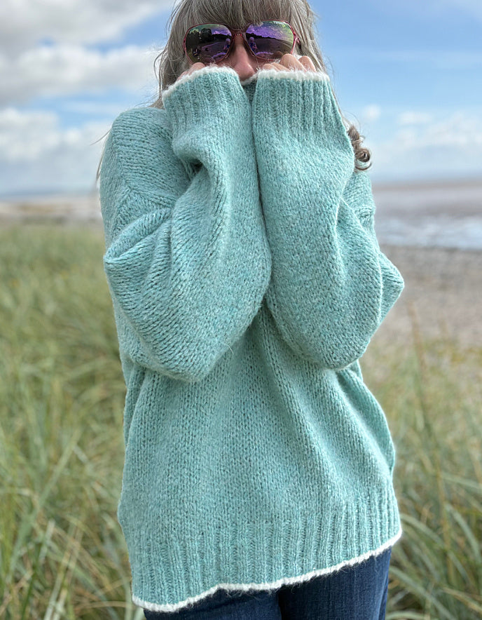 woman wearing a pale blue cosy turtle neck sweater with jeans