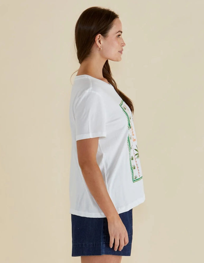 Woman wearing a white t-shirt with a graphic design on a beige background