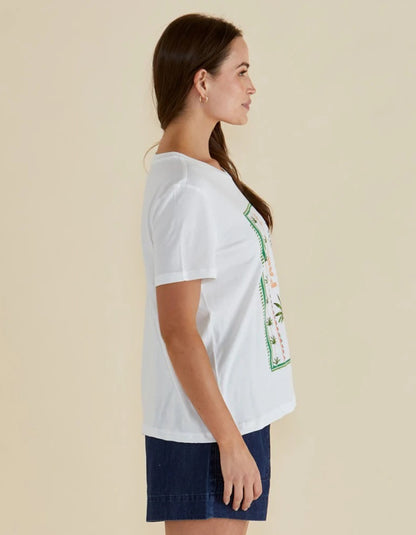 Woman wearing a white t-shirt with a graphic design on a beige background