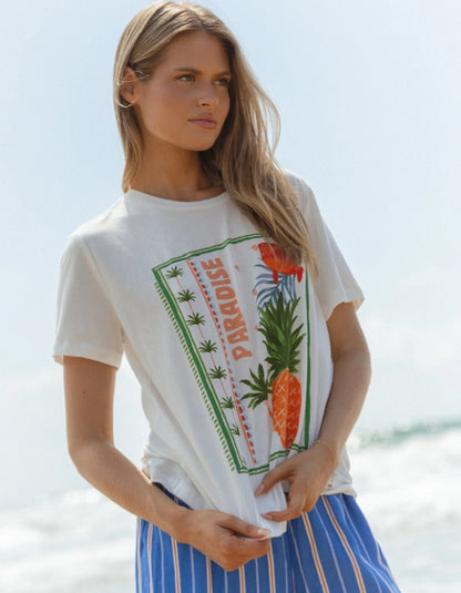 Woman wearing a white t-shirt with a tropical design on a beach