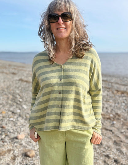 woman wearing striped green and yellow cardigan with soft green trousers