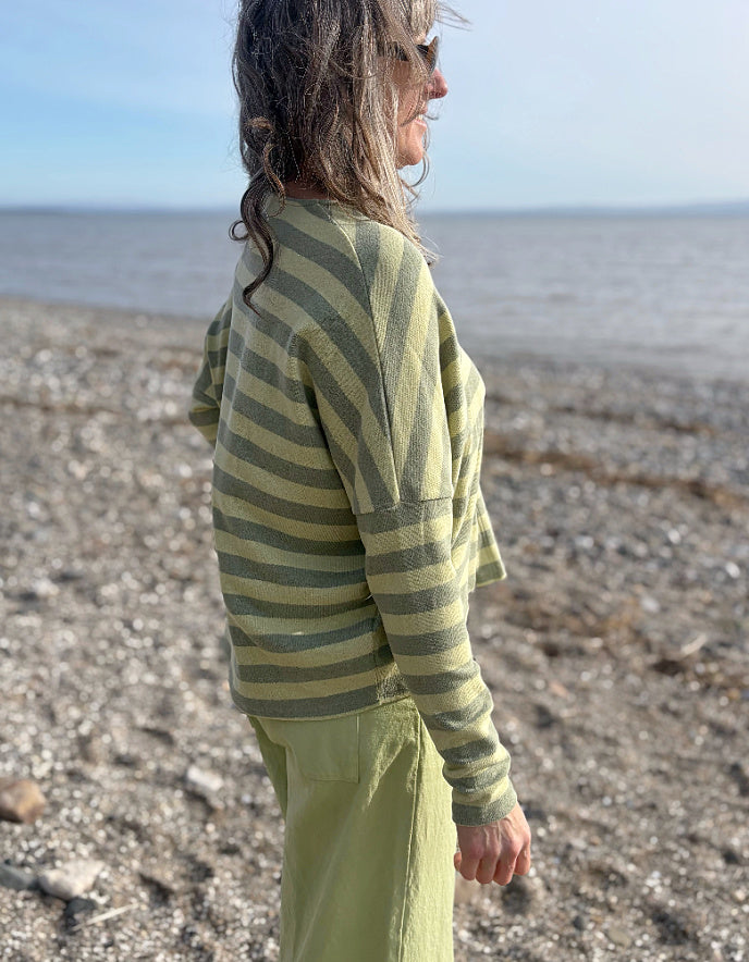 woman wearing striped green and yellow cardigan with soft green trousers