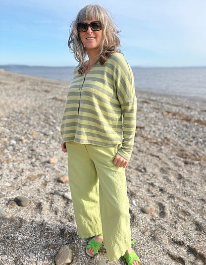 woman wearing striped green and yellow cardigan with soft green trousers