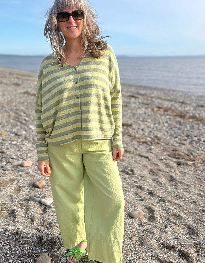 woman wearing striped green and yellow cardigan with soft green trousers