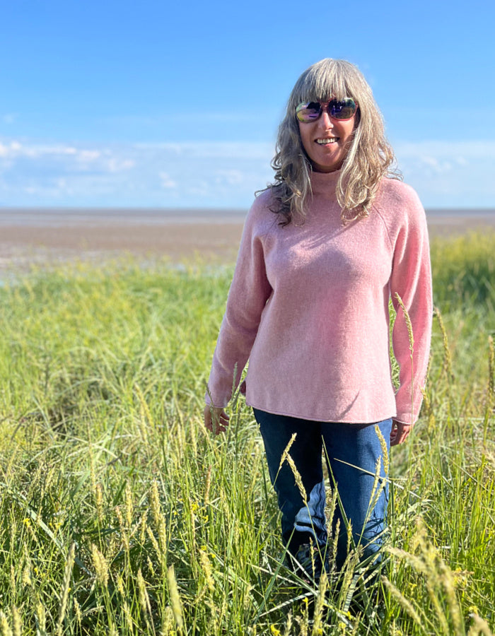 soft pink wool sweater with oversized fit and raglan sleeves and floppy turtle neck