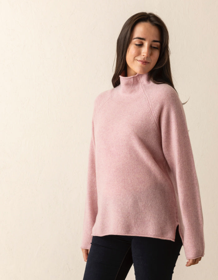 soft pink wool sweater with oversized fit and raglan sleeves and floppy turtle neck