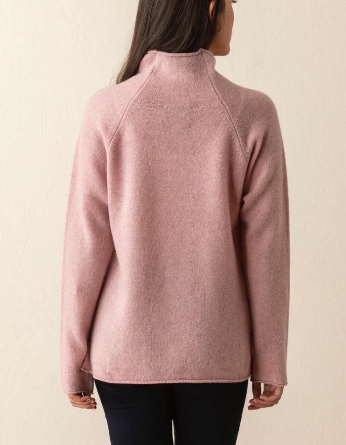 soft pink wool sweater with oversized fit and raglan sleeves and floppy turtle neck