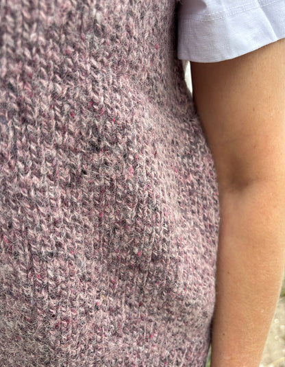 Close-up of a textured pink donegal tweed garment with a blurred background