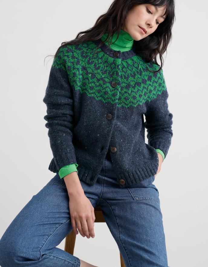 Person wearing a dark blue and green patterned sweater on a light gray background