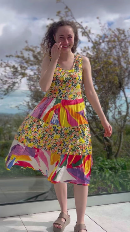 sleeveless cotton sundress with bright coloured print in collage style, tiered skirt and two front patch pockets