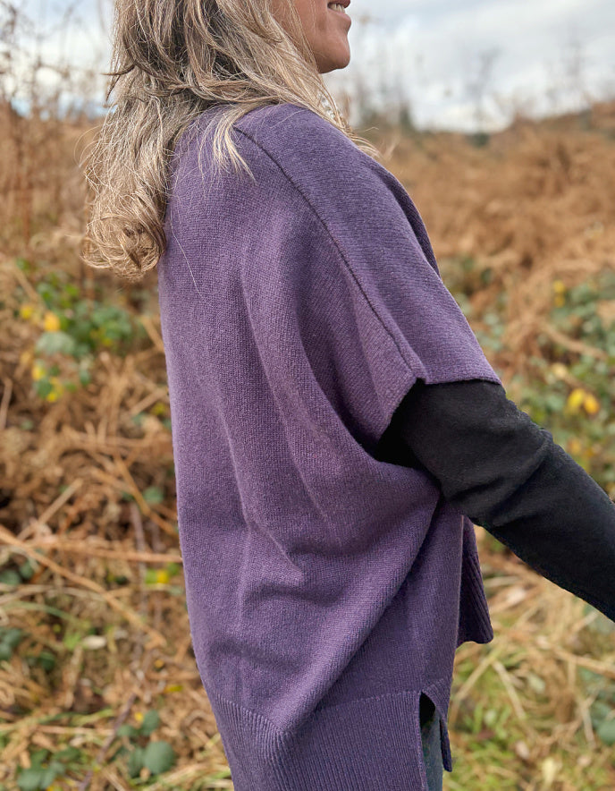 Person wearing a purple sweater in a field