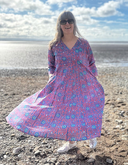 midi length cotton dress with full skirt and pockets and 3/4 length sleeves and V neckline in red and blue hand blocked print