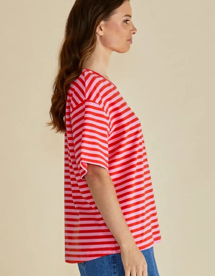 Woman wearing a red and white striped shirt against a beige background