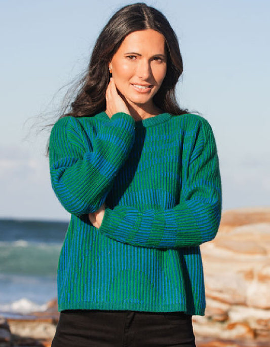 woman wearing a blue and green jacquard wool sweater on a beach