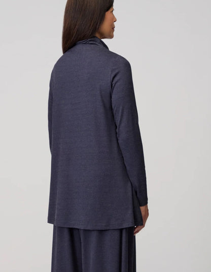Person wearing a long dark blue jacket on a light gray background