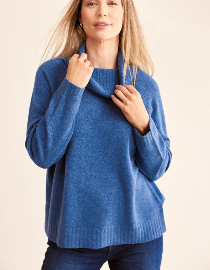 Woman wearing a blue sweater against a beige background